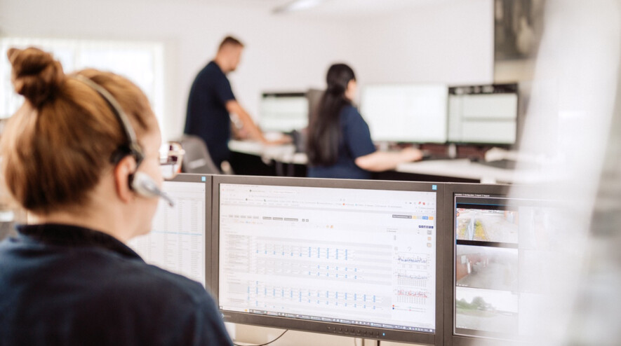 Security employee monitors screens in alarm receiving center