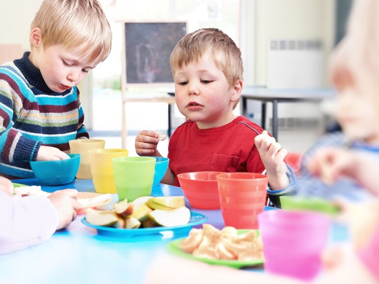 Kindergarten children eat fruits