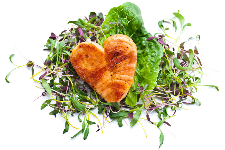 Heart shaped fish fillet on a bed of lettuce