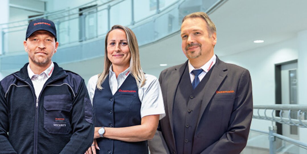 Group photo of 3 smiling Dussmann employees from the security service division.