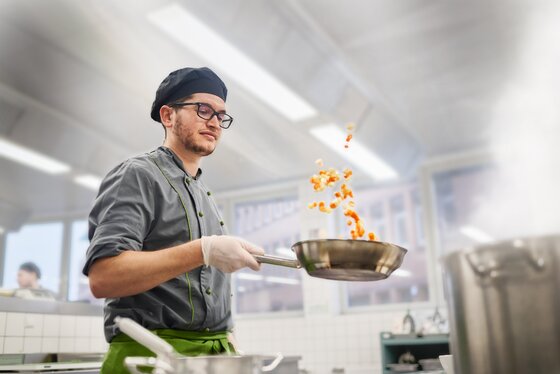 Cook swings pan  