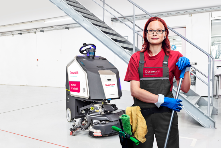  Cleaning worker in front of a scrubber dryer