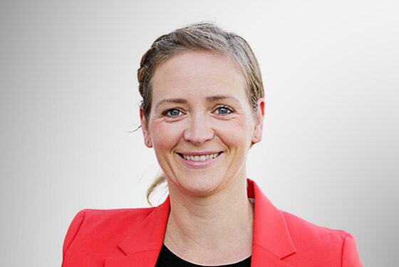 Portraitbild von Jenny Michaelis die einen roten Blazer trägt.